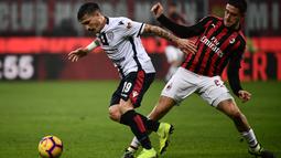 Bek AC Milan, Davide Calabria mencoba menghentikan pergerakan pemain Cagliari pada laga lanjutan Serie A yang berlangsung di stadion San Siro, Milan, Senin (11/2). AC Milan menang 3-0 atas Cagliari. (AFP/Marco Bertorello)