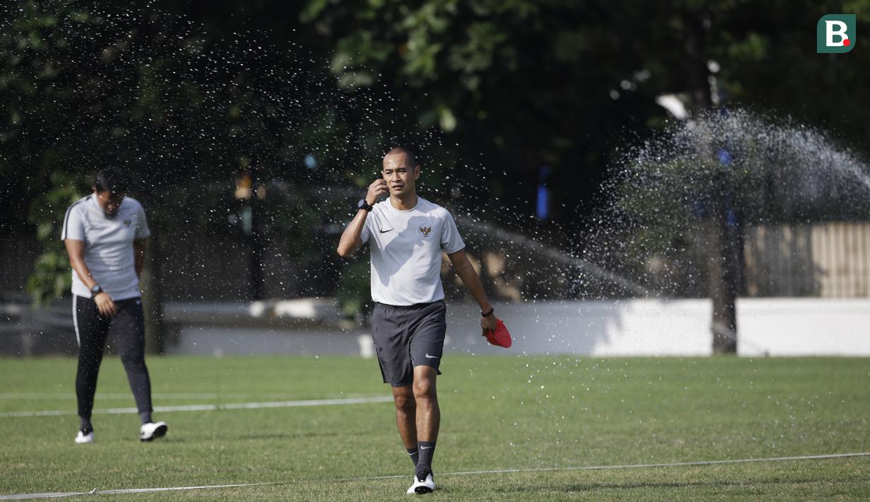 Asisten pelatih Timnas Indonesia, Kurniawan Dwi Julianto, mengamati anak asuhnya saat latihan di Lapangan ABC Senayan, Jakarta, Selasa (20/11). Latihan ini persiapan jelang laga Piala AFF 2018 melawan Filipina. (Bola.com/Vitalis Yogi Trisna)