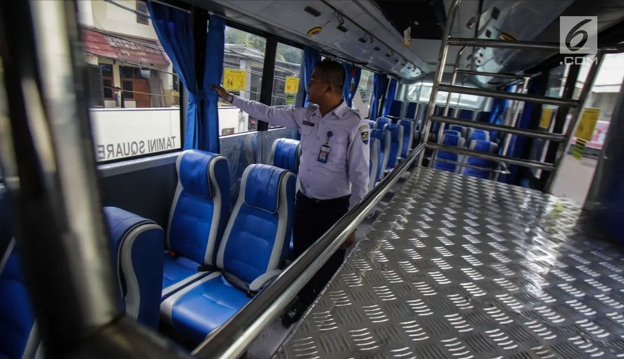 Petugas mengecek kondisi dalam bus Transjabodetabek Premium milik Perum PPD saat menunggu calon penumpang di Tamini Square, Jakarta, Kamis (14/12). (Liputan6.com/Faizal Fanani)