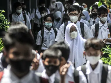 Suasana murid saat jam pulang sekolah usai kegiatan Pembelajaran Tatap Muka (PTM) 100 Persen di SMP Negeri 9 Depok, Cipayung, Senin (24/1/2022). Pemerintah Kota Depok hari ini mulai menggelar PTM 100 persen secara serentak untuk tingkat TK, SD, dan SMP. (merdeka.com/Iqbal S Nugroho)