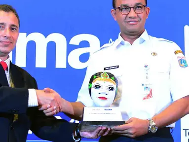 Gubernur DKI Jakarta Anies Baswedan menerima plakat dari Direktur Eksekutif Pusat Mediasi Nasional (PMN) Fahmi Shahab saat pembukaan Konferensi Asian Mediation Association (AMA) ke-5 di Jakarta, Rabu (24/10). (Liputan6.com/JohanTallo)