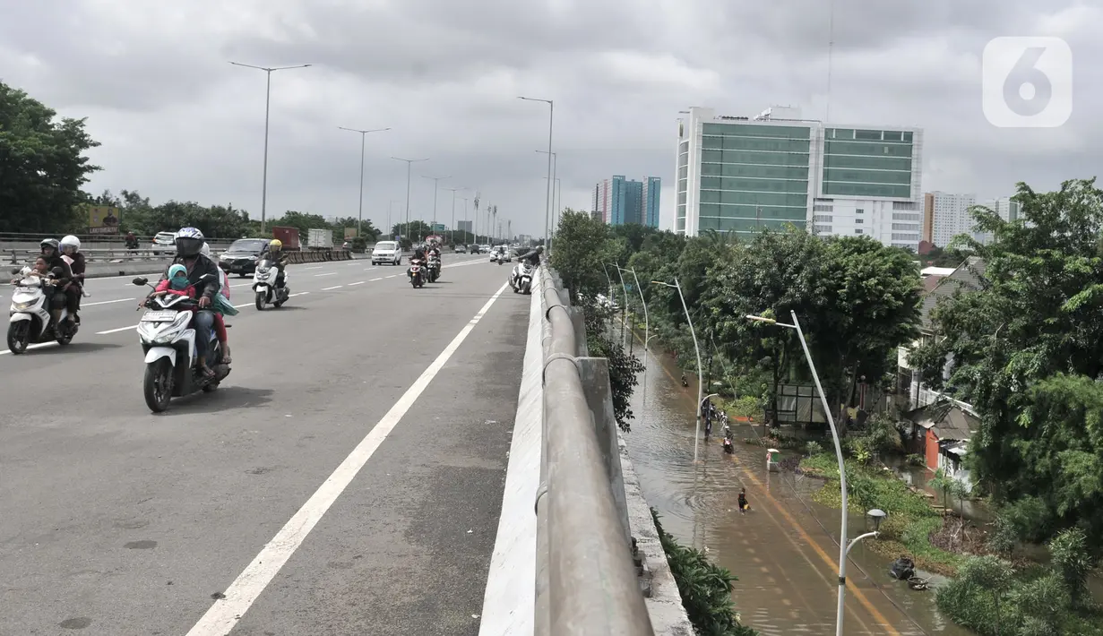 Pengendara motor melewati jalan tol di kawasan Cempaka Putih, Jakarta, Minggu (23/2/2020). Banjir yang melanda kawasan tersebut sejak dini hari tadi melumpuhkan akses di Jalan Ahmad Yani sehingga Gerbang Tol Pulomas dibuka untuk pengendara sepeda motor. (merdeka.com/Iqbal S. Nugroho)