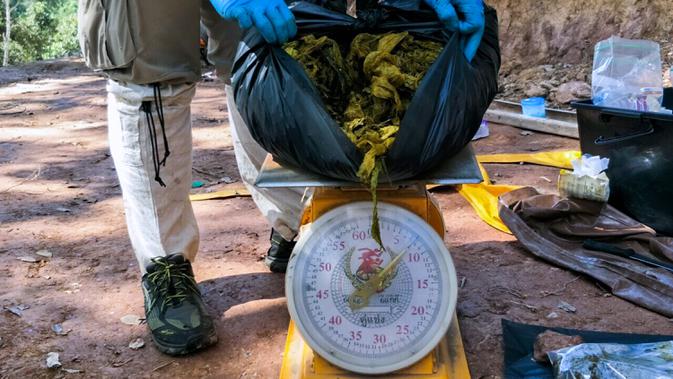 Gambar yang diambil 25 November 2019, dokter hewan menimbang sampah plastik yang ditemukan dalam perut rusa di Taman Nasional Khun Sathan, Thailand. Rusa liar berumur 10 tahun itu ditemukan mati setelah menelan 7 kilogram kantong plastik dan sampah lain. (HO/Office of Protected Area Region 13/AFP)
