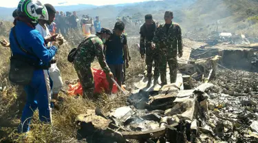 Tentara memeriksa puing dari pesawat Hercules TNI AU yang jatuh di kawasan Wamena, Papua, Minggu (18/12). Pesawat jenis C-130 HS A-1334 itu diduga jatuh menabrak Gunung Tugima sesaat akan mendarat di Bandara Wamena. (HANDOUT/SEARCH AND RESCUE TEAM/AFP)