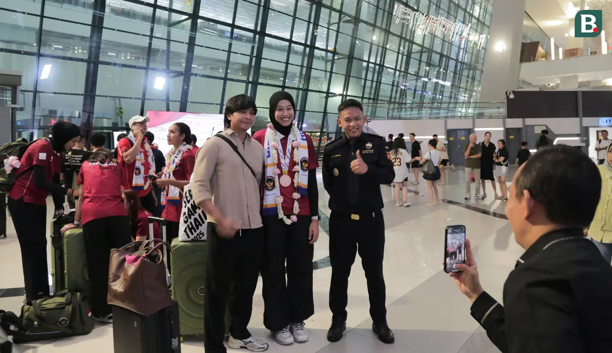 Atlet Voli, Megawati Hangestri Pertiwi, melayani permintaan foto bersama fans setelah acara penyambutan atlet SEA Games 2025 di Bandara Soekarno-Hatta, Tangerang, Selasa (16/12/2025). (Bola.com/M Iqbal Ichsan)