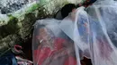Imigran Honduras yang sedang menuju Amerika Serikat tidur menggunakan sepotong plastik di trotoar di Huixtla, Meksiko, 23 Oktober 2018. Presiden AS Donald Trump mengerahkan militer untuk menghalau para imigran. (AP Photo/Moises Castillo)