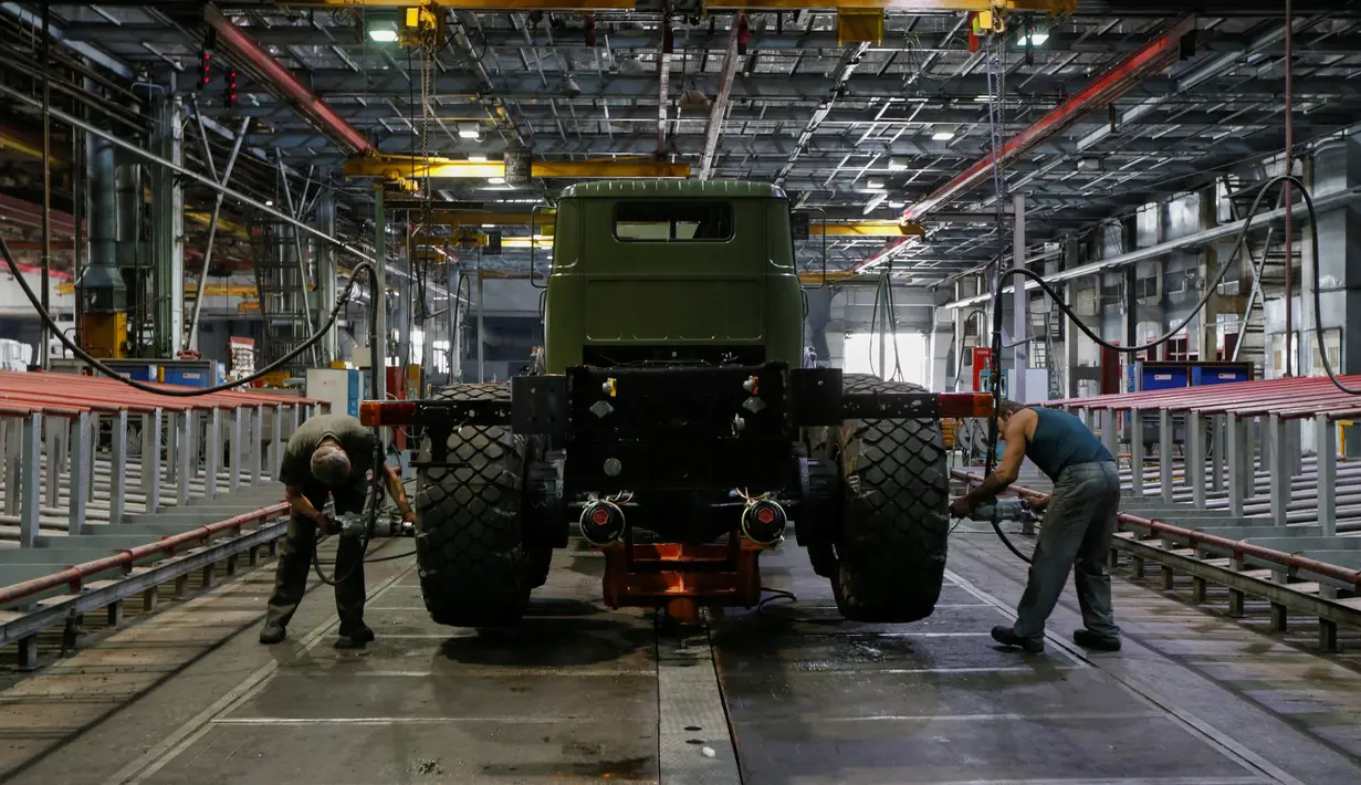 Sejumlah karyawan memasang roda truk lapis baja KrAZ-6322RA di Pabrik AutoKrAZ, Kremenchuk, Ukraina, Selasa (14/6). Truk ini diproduksi dengan berbagai kelebihan untuk keperluan pertahanan. (REUTERS / Valentyn Makarenko)