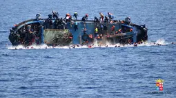 Perahu berpenumpang migran karam di lepas pantai Libya, Rabu (25/5). Angkatan Laut mengatakan 500 orang telah ditarik ke tempat yang aman dan tujuh mayat ditemukan, tetapi operasi penyelamatan terus dilakukan dan angka kematian bisa meningkat. (AFP PHOTO)