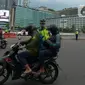 Polisi mengimbau pengguna jalan yang menggunakan kendaraan pribadi mobil dan motor yang berboncengan di Bundaran HI, Jakarta, Jumat (10/4/2020). Penerapan hari pertama PSBB hingga 14 hari kedepan ini dilakukan untuk mencegah penyebaran COVID-19 dan selalu menggunakan masker.(merdeka.com/Imam Buhori)