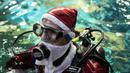 Aquarist Volmer Salvador bersiap berenang dalam akuarium AquaRio mengenakan kostum Sinterklas saat musim Natal di Rio de Janeiro, Brasil, 20 Desember 2021. Dengan luas bangunan sekitar 26.000 meter persegi, AquaRio dianggap sebagai akuarium laut terbesar di Amerika Selatan. (AP Photo/Bruna Prado)
