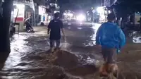 Warga saat melintasi banjir bandang di Jalan Raya Palabuhanratu, Kabupaten Sukabumi. (Liputan6.com/Istimewa).