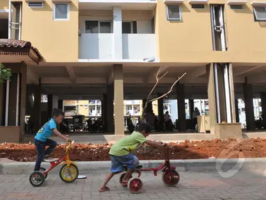 Anak kecil bermain sepeda di halaman Rusunawa Muara Baru, Jakarta, Kamis (21/05/2015). Fasilitas rusunawa muara baru akan di tambah dan diperlengkap seperti pembangunan Ruang Publik Terpadu Ramah Anak (RPTRA). (Liputan6.com/Herman Zakharia)