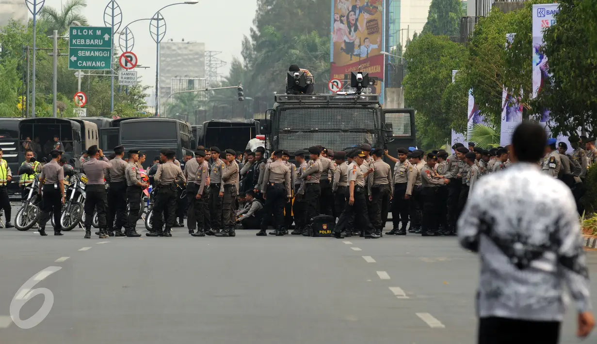 Ratusan anggota kepolisian bersiaga menutup ruas jalan Asia Afrika Jakarta, Selasa (15/9/2015). Sebagian ruas jalan Asia Afrika ditutup sementara saat para guru honorer melakukan aksi menuntut pengangkatan sebagai PNS. (Liputan6.com/Helmi Fithriansyah)