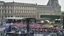 Ratusan pendukung Emmanuel Macron berkumpul di depan piramida kaca di taman museum Louvre, Paris, Minggu (7/5). Ratusan pendukung Emmanuel Macron menyambut kemenangan kandidat termuda yang terpilih sebagai presiden Prancis itu. (PHILIPPE LOPEZ/POOL/AFP)