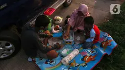 Sejumlah pemudik berbuka puasa Ramadhan sambil beristirahat di KM 102 ruas Tol Cikopo-Palimanan, Subang, Jawa Barat, Kamis (28/4/2022). Padatnya sejumlah rest area di sepanjang jalan tol Trans Jawa membuat pemudik memanfaatkan bahu jalan untuk berbuka puasa dan istirahat sejenak. (Liputan6.com/Herman Zakharia)