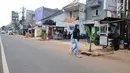 Pejalan kaki melintasi lubang bekas galian yang ditanami pohon pisang di pinggir Jalan Raya Margonda, Depok, Senin (4/3/2019). Aksi tanam pohon pisang itu sebagai protes warga akibat banyaknya lubang galian di Jalan Margonda (Liputan6.com/Herman Zakharia)