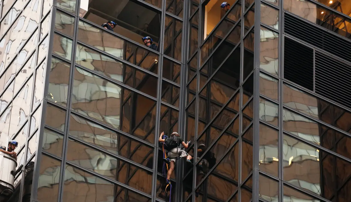 Aksi nekat seorang pria berambut gondrong memanjat gedung Trump Tower di New York, AS, Rabu (10/8). Sejumlah petugas NYPD menunggu pria tersebut sebelum bersiap-siap menahannya ketika mencapai lantai 21. (REUTERS/Lucas Jackson)