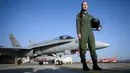 Pilot jet tempur Swiss, Fanny Chollet berpose di dekat pesawat F/A-18 di Pangkalan Udara Payerne, Swiss, (19/12). Fanny Chollet 28 tahun yang dijuluki 'Shotty' merupakan pilot jet tempur perempuan pertama Swiss. (AFP Photo/Fabrice Coffrini)