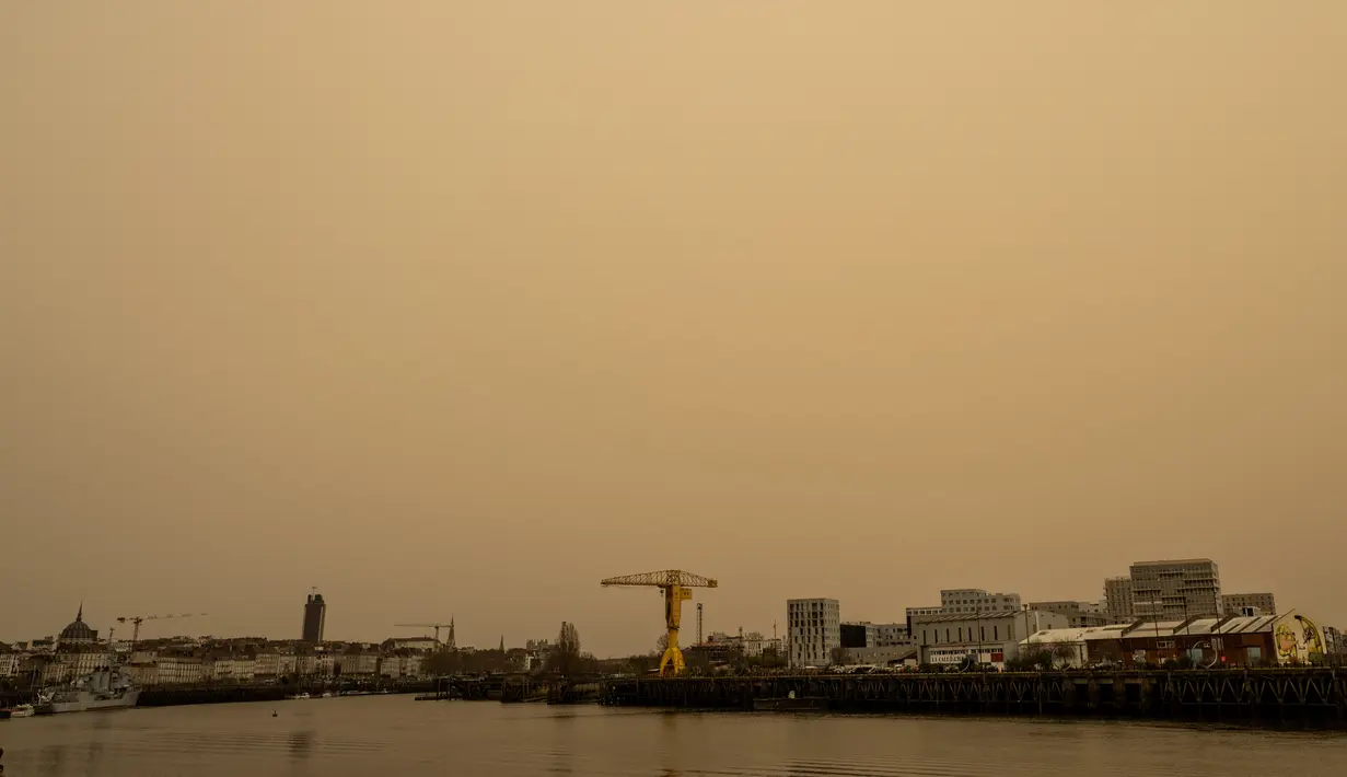 Kota Nantes tampak diselimuti debu dari gurun Sahara berwarna kuning tua di Prancis barat (15/3/2022). Badai di gurun Sahara menciptakan badai besar hembusan angin, yang mengangkat pasir ke udara. (AFP/Loic Venance)