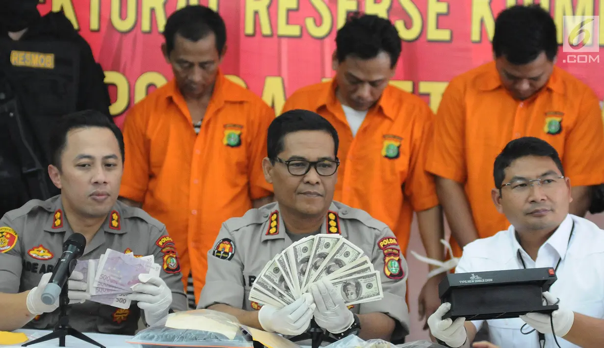 Kabid Humas Polda Metro Jaya Kombes Pol Argo Yuwono menunjukan uang palsu di Polda Metro Jaya, Jakarta, Senin (8/4). Subdit 3 Resmob Dit Reskrimum Polda Metro Jaya berhasil melakukan pengungkapan kasus pemalsuan mata uang dengan mengamankan tiga orang tersangka . (Liputan6.com/Herman Zakharia)