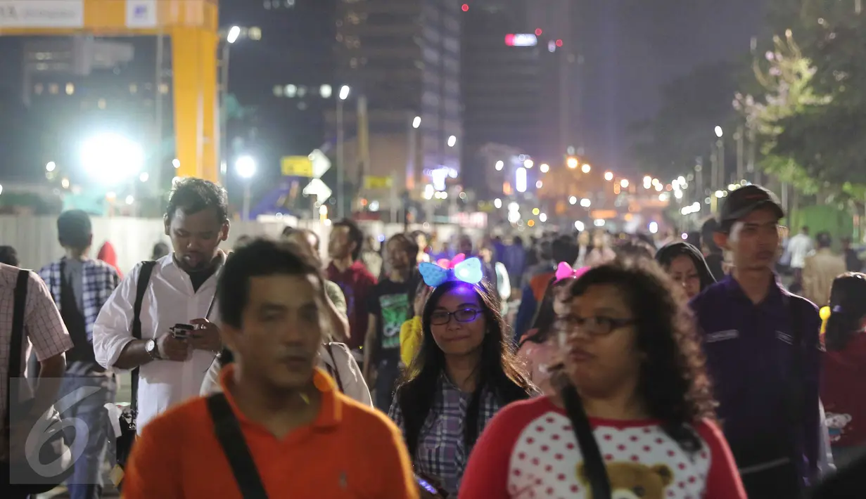 Pengunjung berjalan di kawasan Bundaran HI, Jakarta, Kamis (31/12). Kendaraan bermotor tidak diijinkan melewati kawasan untuk pelaksanaan perayaan tahun baru 2016. (Liputan6.com/Angga Yuniar)