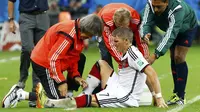 Pemain tengah Timnas Jerman, Bastian Schweinsteiger, harus mendapat perawatan tim medis akibat cedera saat berlaga kontra Aljazair di Stadion Beira Rio, Porto Alegre, (1/7/2014). (REUTERS/Stefano Rellandini) 
