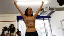 Seorang aktivis Femen saat melakukan aksi toplessnya di tempat pemungutan suara di Milan, Italia, Minggu (4/3). Pesan tersebut berbunyi " Berlusconi, Anda telah berakhir". (Miguel MEDINA/AFP)