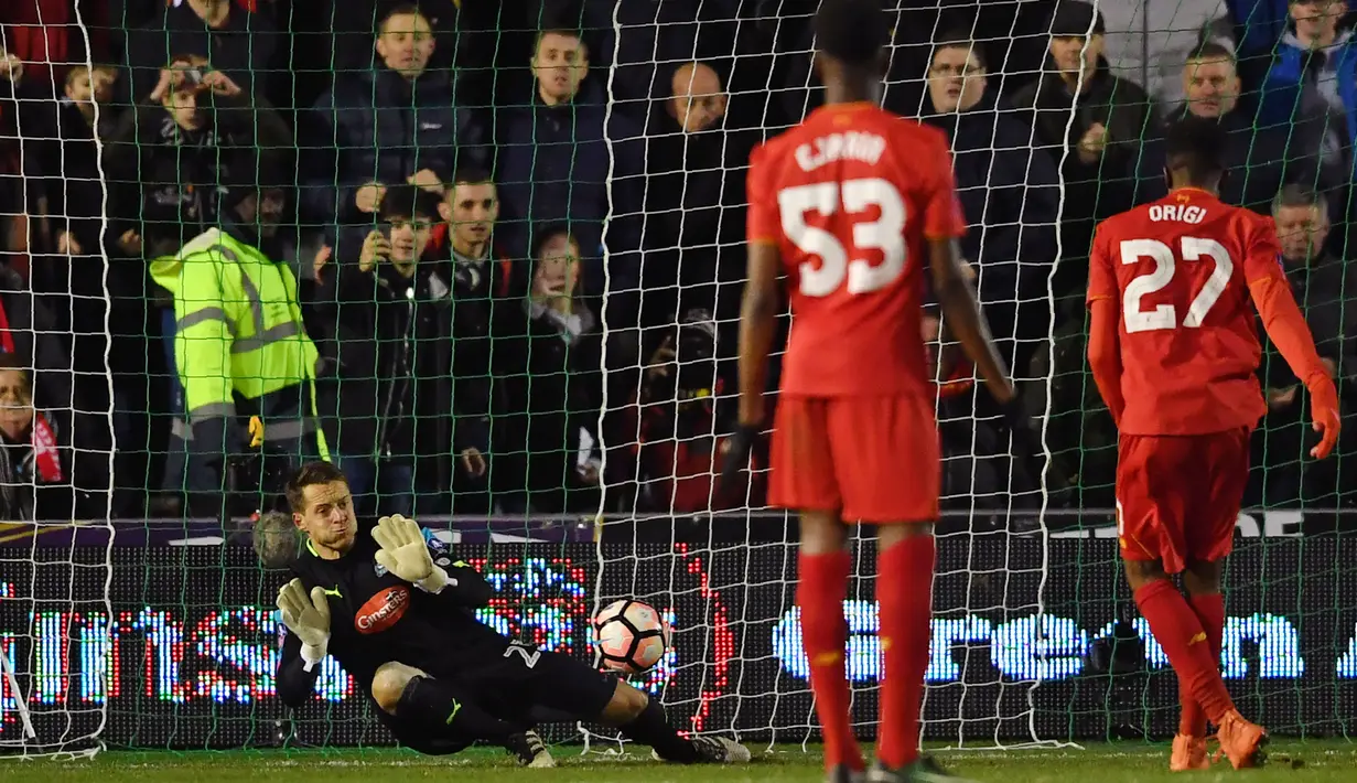 Kiper Plymouth, Luke McCormick (kiri) menahan tembakan penalti pemain Liverpool, Divock Origi pada babak ketiga Piala FA di Home Park, Plymouth, (18/1/2017).  Liverpool menang 1-0.  (AFP/Ben Stansall)