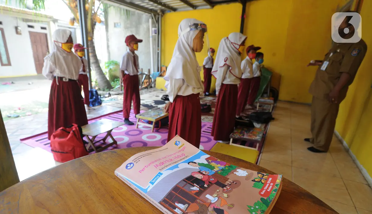 Murid kelas III SDN 02 Pondok Petir mengikuti kegiatan belajar mengajar di teras rumah salah satu siswa di Depok, Senin (31/08/2020). Mereka belajar 2 - 3 minggu sekali karena para siswa kesulitan belajar daring akibat beban paket data dan tidak semua memiliki smartphone. (merdeka.com/Arie Basuki)