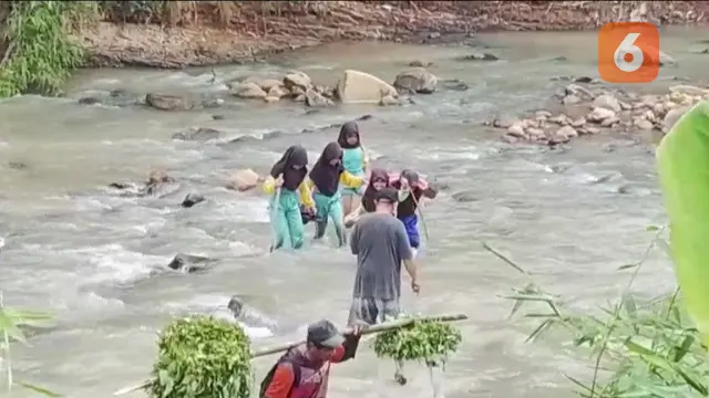 Pelajar SD Negeri Cibadak, Neglasari, Kecamatan Lengkong saat sebrangi sungai Cikaso menuju sekolah. (Liputan6.com/Fira Syahrin).