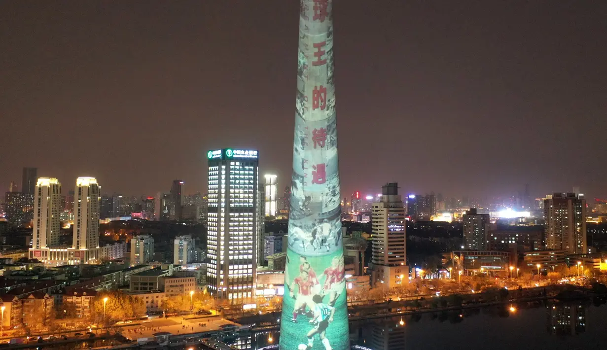 Foto udara menunjukkan mantan pesepak bola Argentina Diego Maradona diproyeksikan di Menara TV Tianjin di Kota Tianjin, China utara (26/11/2020). Maradona tutup usia di usia 60 tahun akibat serangan jantung pada Rabu (25/11). (Xinhua/Li Ran)