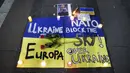 Simbol-simbol dan sedikit memorial dipajang saat demonstrasi menentang invasi Rusia ke Ukraina di Piazza Duomo, Milan, Italia, 1 Maret 2022. (Alessandro Bremec/LaPresse via AP)