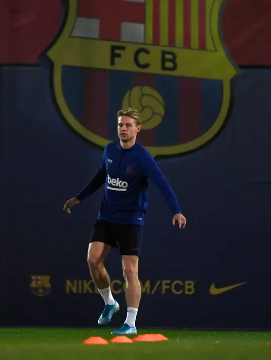 Gelandang Barcelona, Frenkie De Jong melakukan pemanasan saat mengikuti sesi latihan tim di Joan Gamper Sports City di Sant Joan Despi (17/12/2019). Barcelona akan bertanding melawan Real Madrid dalam laga El Clasico di Camp Nou. (AFP/Lluis Gene)