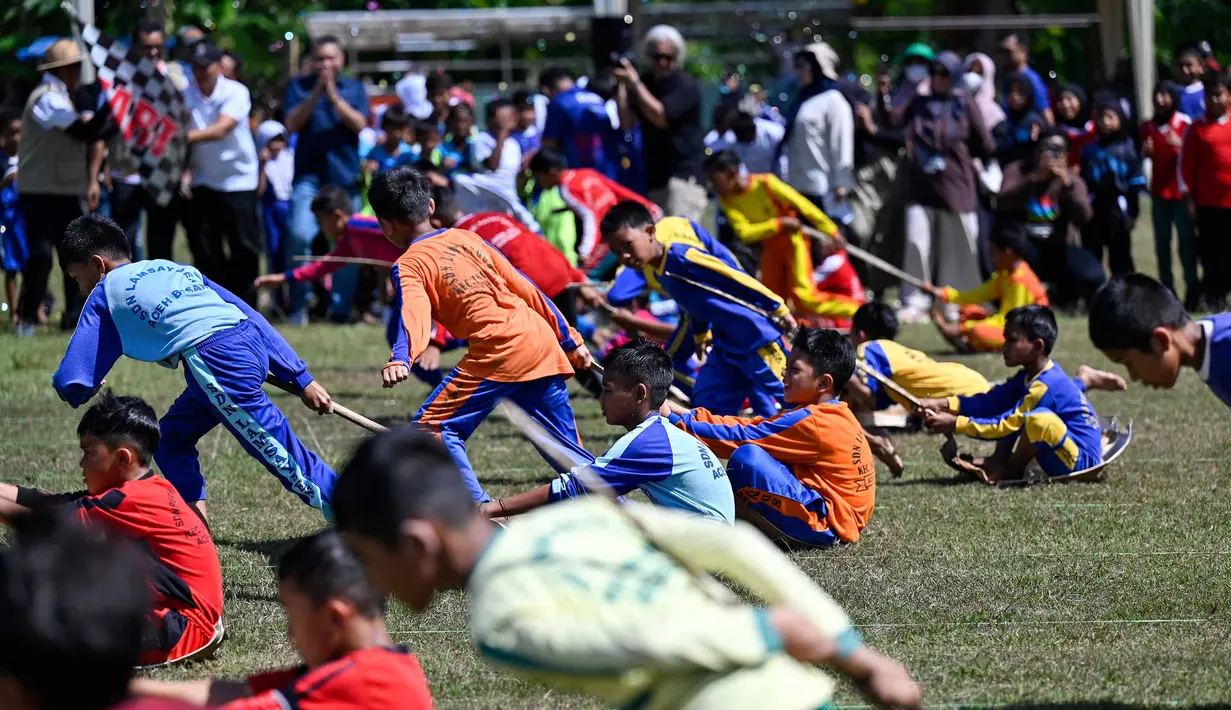 Siswa mengikuti permainan tradisional tarik upih pinang (tarek situek) pada Festival Permainan Tradisional Anak di Desa Wisata Lubok Sukon, Kecamatan Ingin Jaya, Aceh Besar, Aceh, Sabtu (25/7/2026). (AFP/ Chaideer Mahyuddin)