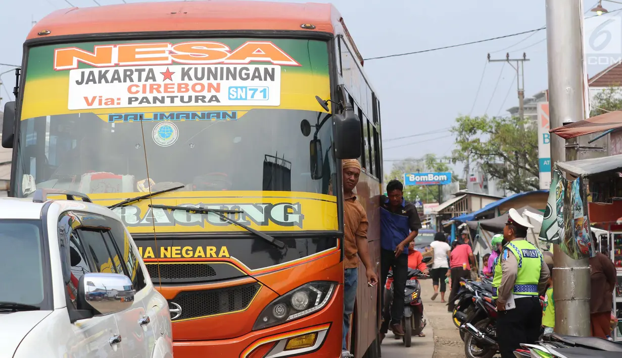 Petugas polisi mengatur lalu lintas di pasar Tumpah Bangkir Indramayu, Jawa Barat, Jumat (30/6). Sebaliknya kearah Indramayu Kota mengalami kemacetan arus lalu lintas sepanjang 3 Km. (Liputan6.com/Helm Afandi)
