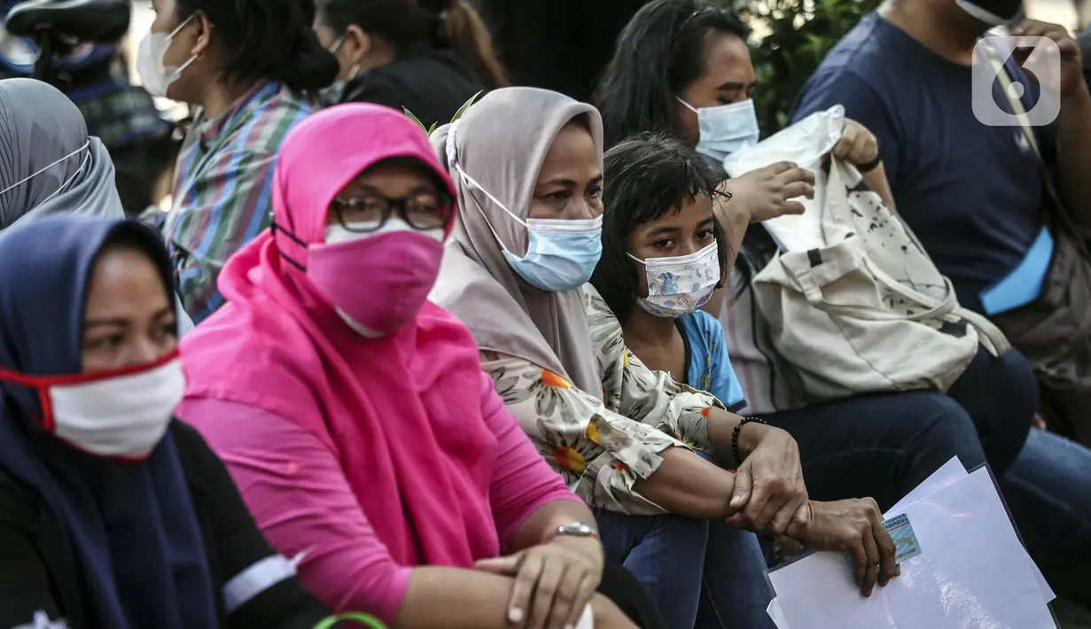 Warga menunggu untuk menerima bantuan sosial (bansos) di kawasan Kedoya Selatan, Jakarta Barat, Rabu (28/7/2021). Bansos ini merupakan alokasi dana yang bersumber dari APBD DKI Jakarta dan menyasar 1.700.379 orang. (Liputan6.com/Johan Tallo)
