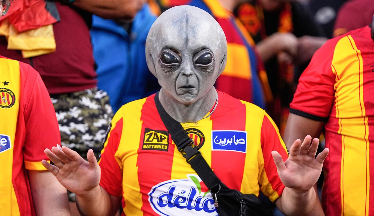 Seorang suporter Esperance de Tunis menggunakan topeng alien saat mendukung timnya melawan Flamengo pada pertandingan Piala Dunia Antarklub 2025 di Lincoln Financial Field, Philadelphia, Selasa (17/6/2025). (AP Photo/Chris Szagola)