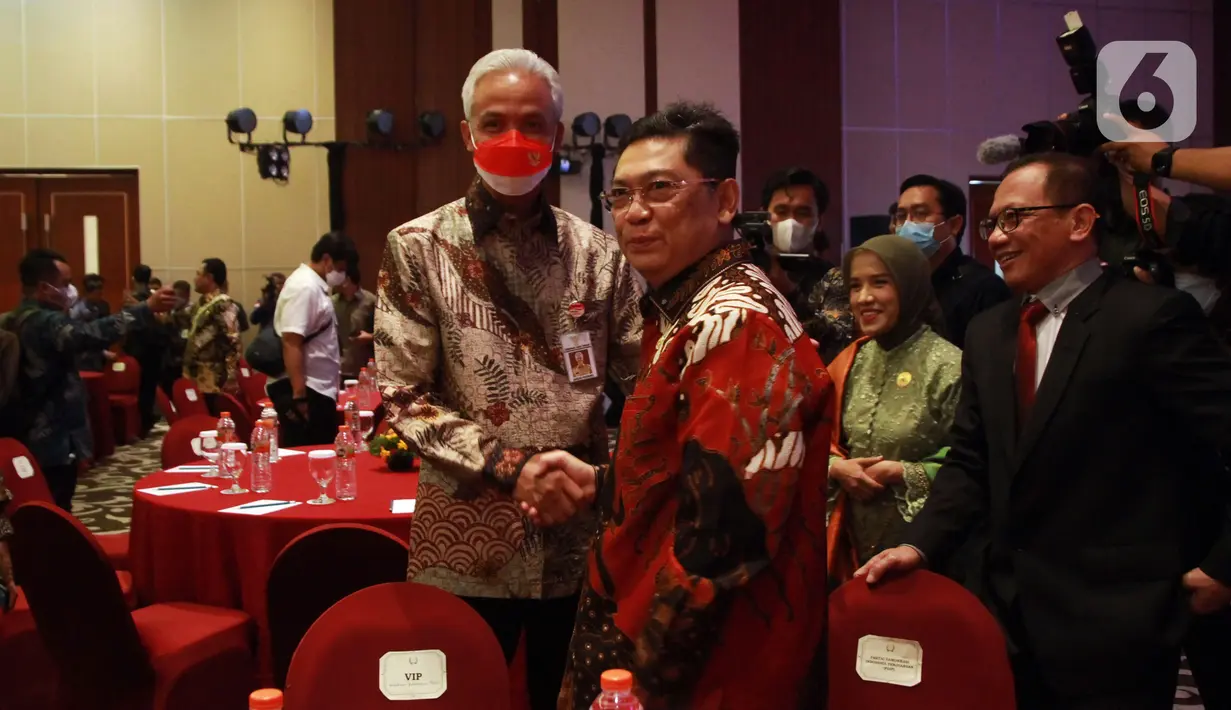 Ketua DPP PDIP Utut Adianto (kanan) bersalaman dengan Gubernur Jawa Tengah yang juga kader PDIP Ganjar Pranowo saat menghadiri acara Anugerah Keterbukaan Informasi Publik Tahun 2022 di Tangerang, Banten, Rabu (14/12/2022). Partai Demokrasi Indonesia Perjuangan (PDIP) kembali berhasil meraih penghargaan Anugerah Keterbukaan Informasi Publik Tahun 2022 dari Komisi Informasi Pusat (KIP) RI yang diwakili oleh Ketua DPP PDIP Utut Adianto. (Liputan6.com/Johan Tallo)
