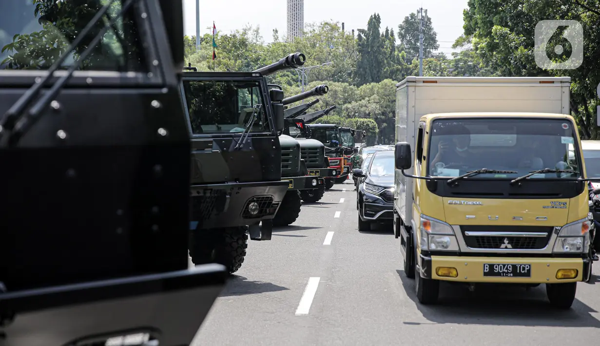 Pengendara melintas di depan sejumlah kendaraan alat utama sistem senjata (alutsista) TNI yang berjajar di kawasan Istana Merdeka, Jakarta, Selasa (4/10/2022). Kegiatan ini dalam rangka HUT ke-77 TNI yang akan berlangsung di Istana Merdeka pada 5 Oktober besok. (Liputan6.com/Faizal Fanani)