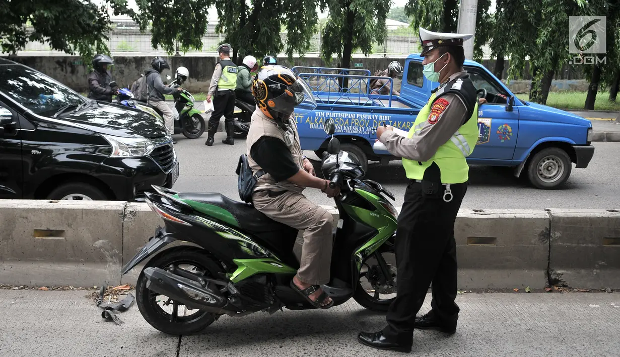 Polisi memberhentikan sepeda motor yang melintasi jalur bus Transjakarta di Jalan Yos Sudarso, Jakarta, Senin (21/1). Razia rutin ini digelar untuk menjaring pengendara yang nekat menerobos jalur bus Transjakarta. (Merdeka.com/Iqbl Nugroho)
