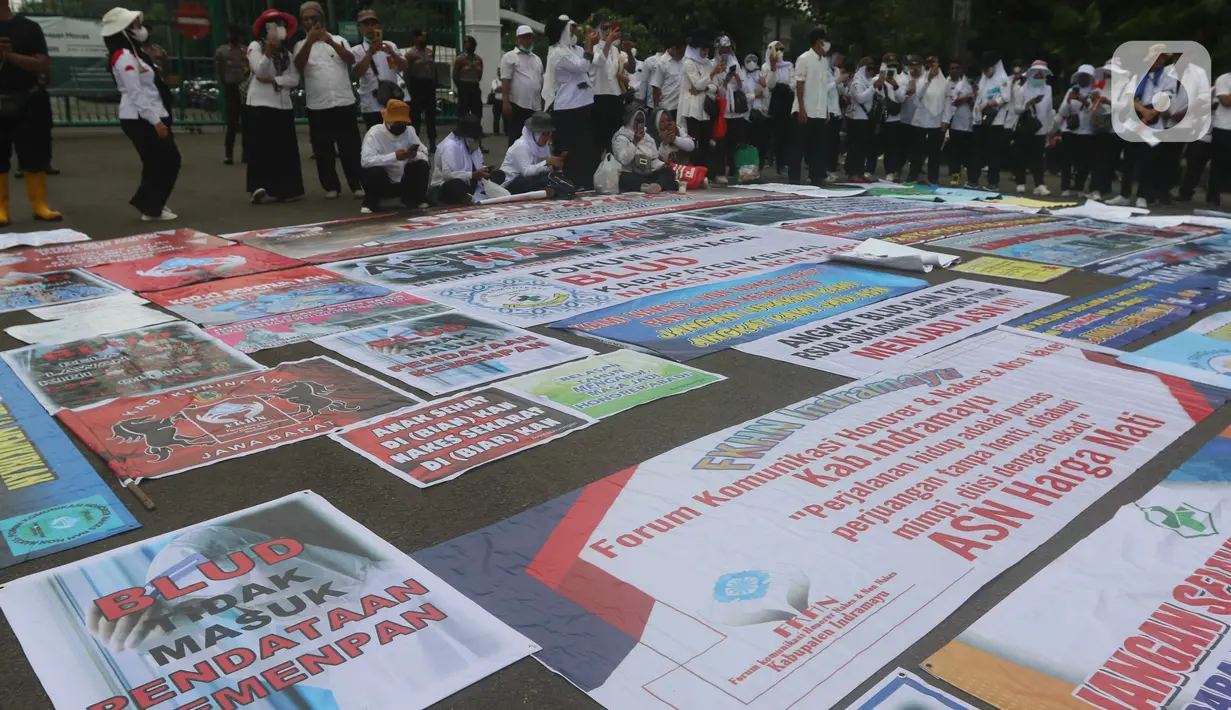 Aksi massa dari Forum Komunikasi Nakes dan Non-Nakes Indonesia (FKHN Indonesia) di kawasan Patung Kuda, Jakarta Pusat, Kamis (22/9/2022). Selain mengenakan pakaian berwarna putih, massa aksi juga terlihat membawa sejumlah atribut. (Liputan6.com/Herman Zakharia)