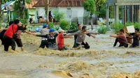Aparat kepolisian dan TNI bersama warga bahu membahu menyelamatkan korban banjir bandang Bonebol. (Liputan6.com/ Arfandi Ibrahim)