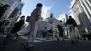 Warga yang mengenakan masker untuk membantu mengekang penyebaran COVID-19 berjalan di sepanjang penyeberangan pejalan kaki di Tokyo, Jepang, Selasa (27/7/2021). Tokyo melaporkan jumlah kasus harian COVID-19 tertinggi beberapa hari setelah Olimpiade dimulai. (AP Photo/Eugene Hoshiko)