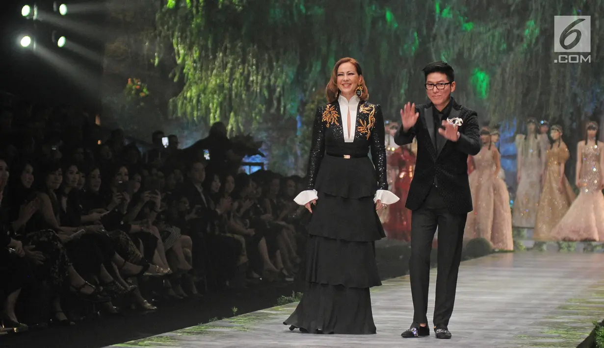 Desainer Sebastian Gunawan tampil di atas catwalk usai memerkan karyanya dalam peragaan busana Aqua Reflections x Sebastian Gunawan di Jakarta, Senin (5/2). (Liputan6.com/Herman Zakharia)