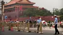 Petugas keamanan berjaga-jaga di depan Gerbang Tiananmen di sebelah Lapangan Tiananmen di Beijing (4/6/2019). Pemerintah China meningkatkan keamanan di sekitar Lapangan Tiananmen di pusat Beijing jelang peringatan tragedi Tiananmen 1989. (AP Photo/Mark Schiefelbein)