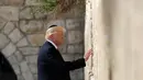 Presiden AS, Donald Trump mengunjungi Tembok Ratapan, tempat suci milik kaum Yahudi, di Yerusalem, Senin (22/5). Trump menatap sesaat tembok itu sebelum akhirnya memasukkan sebuah catatan di antara batu-batu monumental tersebut. (AP Photo/Evan Vucci)