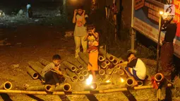 Anak-anak bermain meriam bambu atau bledugan saat merayakan malam takbiran di kawasan Cijeruk, Bogor, Jawa Barat, Selasa (4/6/2019). Bledugan memanfaatkan karbit yang dimasukkan ke dalam meriam bambu untuk kemudian diledakkan. (merdeka.com/Arie Basuki)