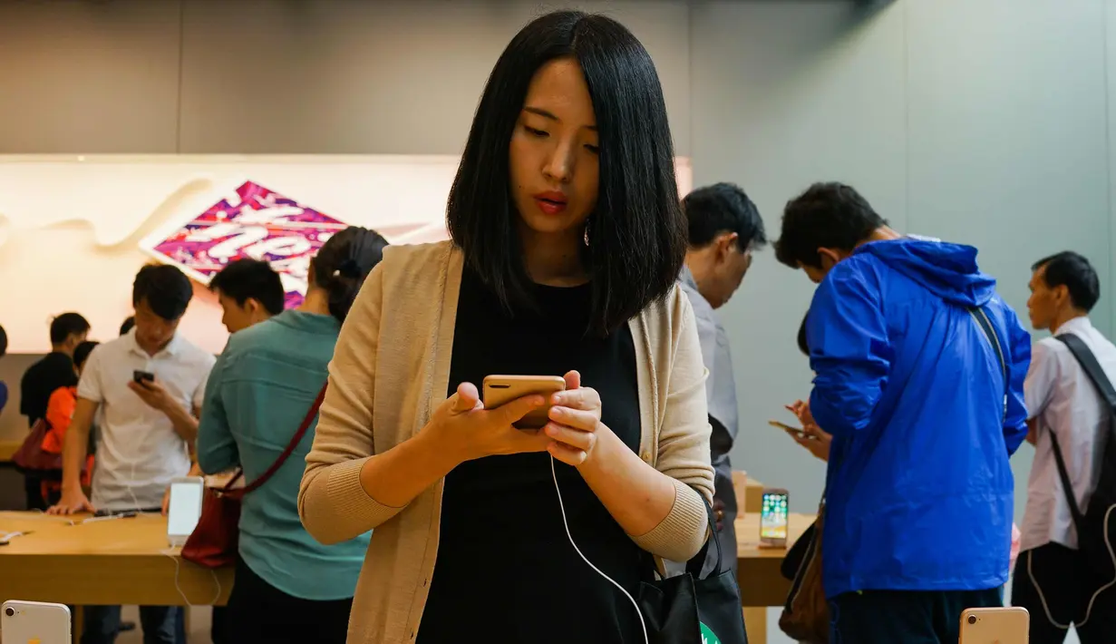 Seorang pembeli melihat Apple iPhone 8 Plus di sebuah showroom Apple di Shanghai (22/9). Apple iPhone 8 dan 8 Plus mulai dijual di China mulai 22 September 2017. (AFP Photo/Chandan Khanna)