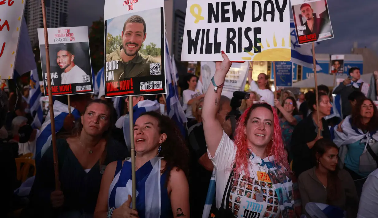Orang-orang yang memegang potret sandera Israel yang masih ditahan di Gaza berkumpul di Lapangan Sandera di Tel Aviv pada dini hari 13 Oktober 2025. (Menahem KAHANA/AFP)