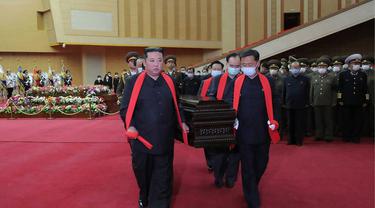 Pemimpin Korea Utara Kim Jong-un (kiri) membawa peti mati di pemakaman kenegaraan seorang perwira tinggi militer. (KCNA VIA KNS/AFP)